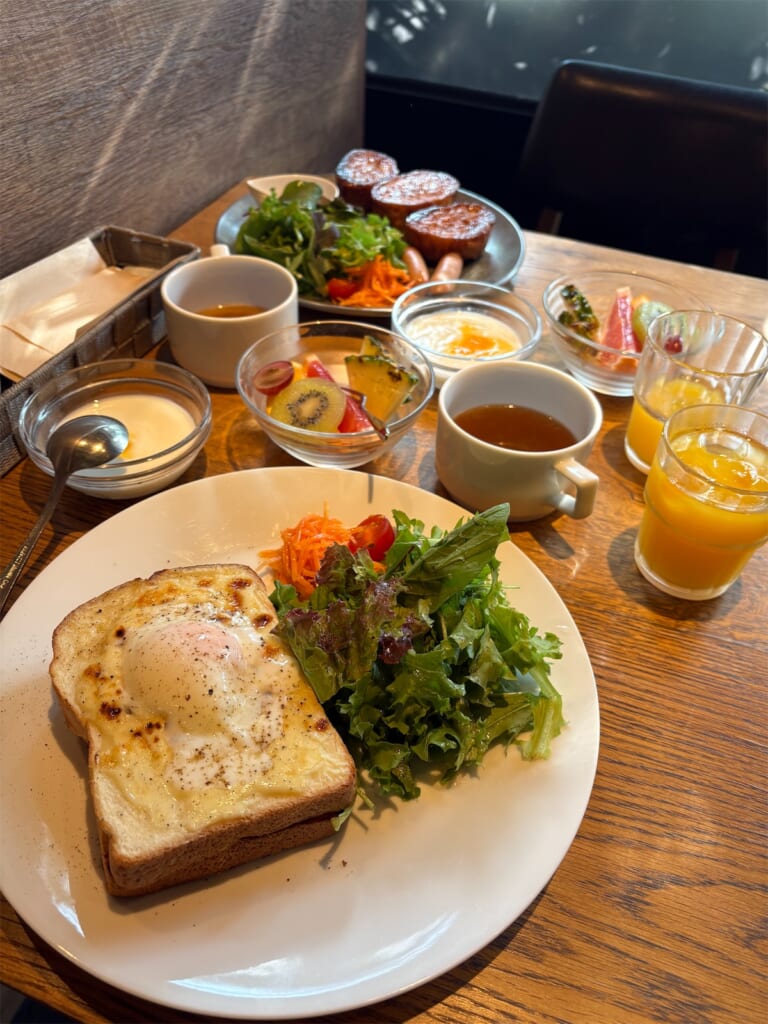 ホテルコルディア大阪の朝食。目玉焼きをのせたトーストのプレートとサラダ、フルーツ、ヨーグルト