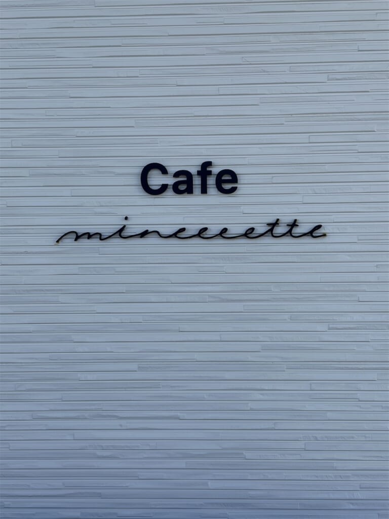 白い壁に「Cafe mineeeette」と書かれたお店の看板