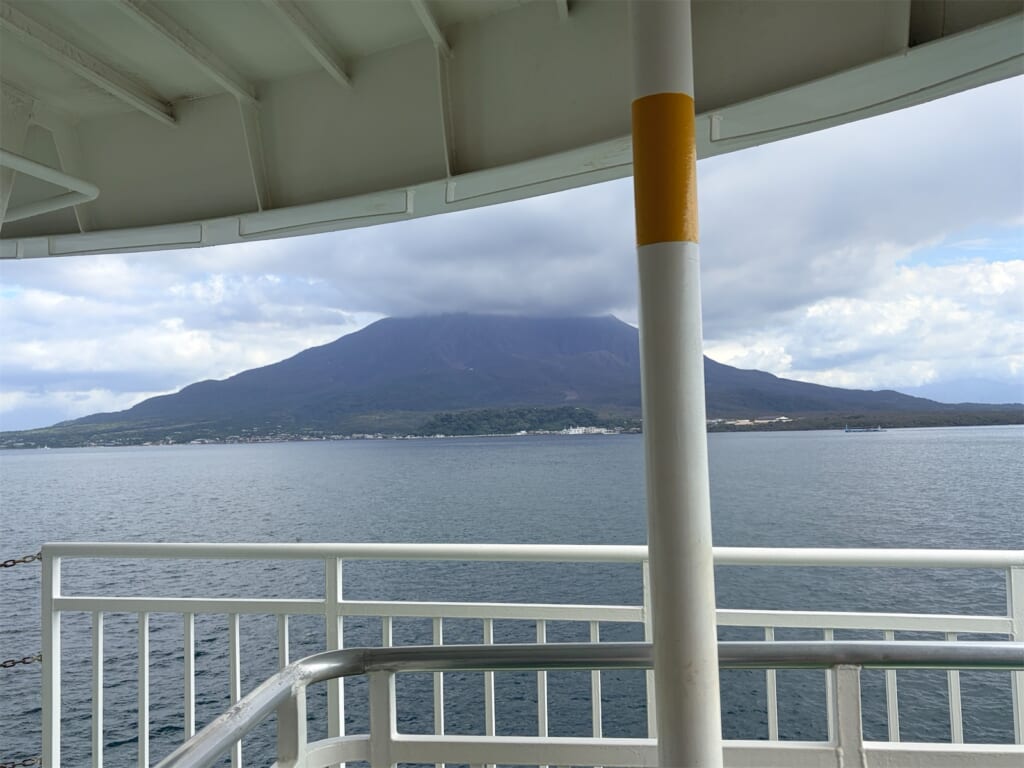 桜島フェリーのデッキから見た、雲がかかった桜島と錦江湾