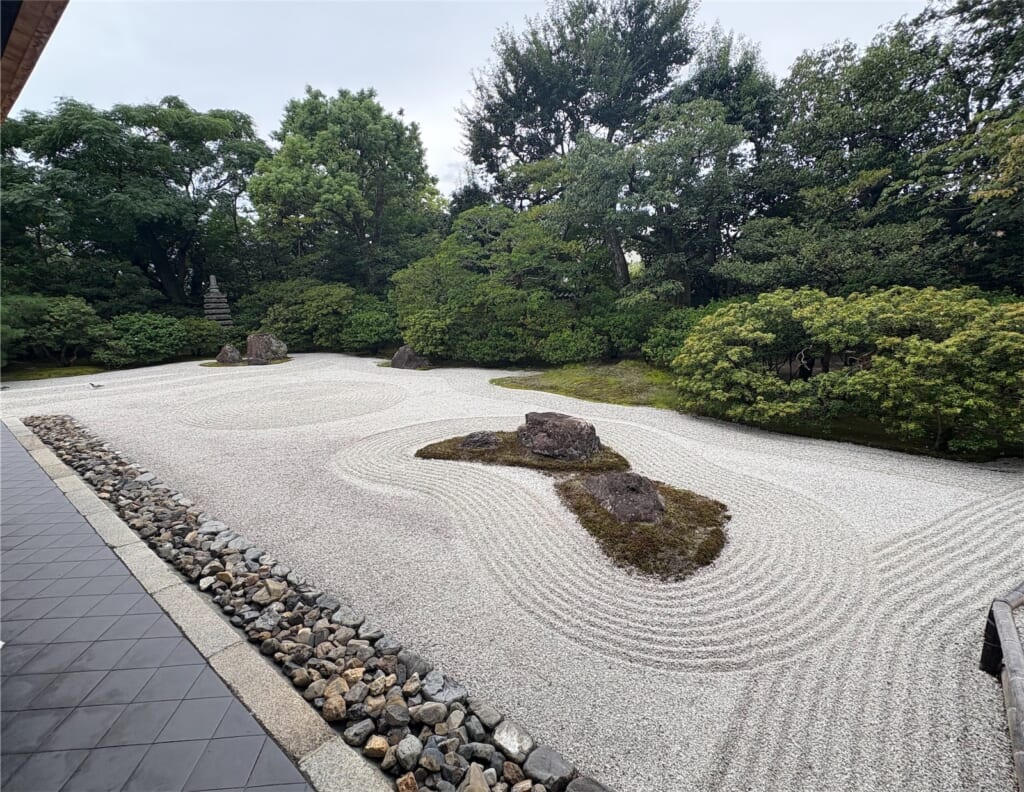 白砂に波のような砂紋が描かれ、苔と石が置かれた方丈前の枯山水庭園