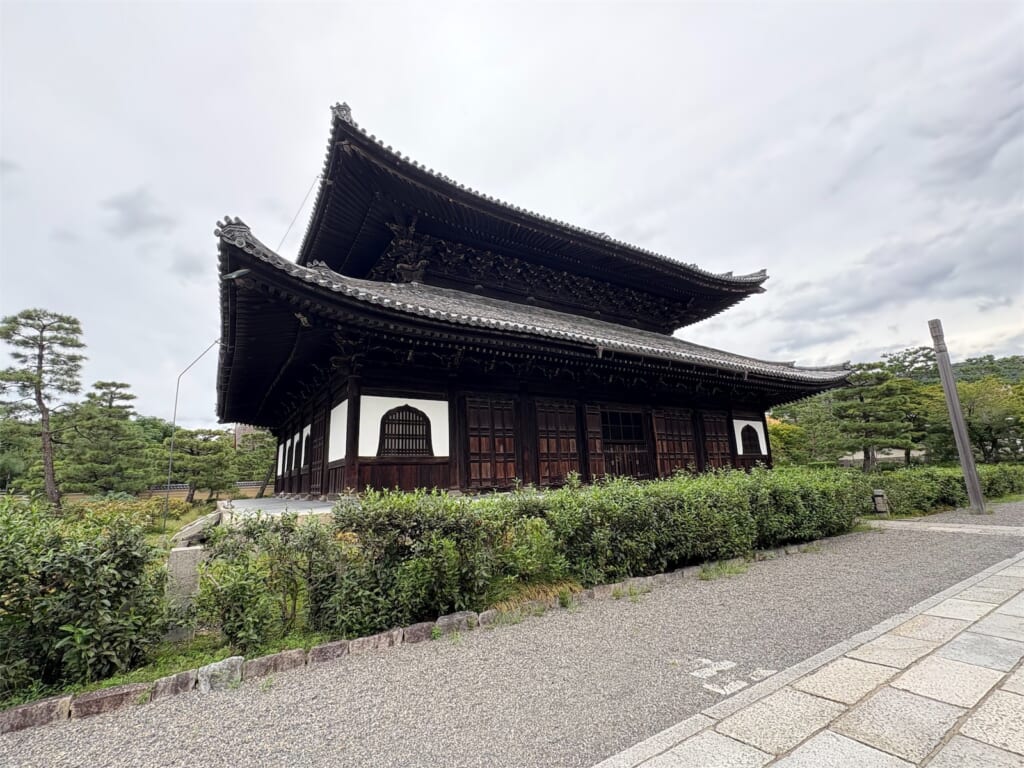 曇り空の下に建つ建仁寺の法堂と、手前の植え込み