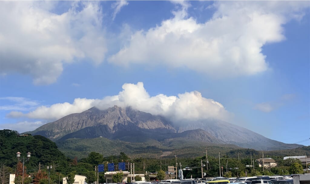 青空の下、雲をまとった桜島の山肌