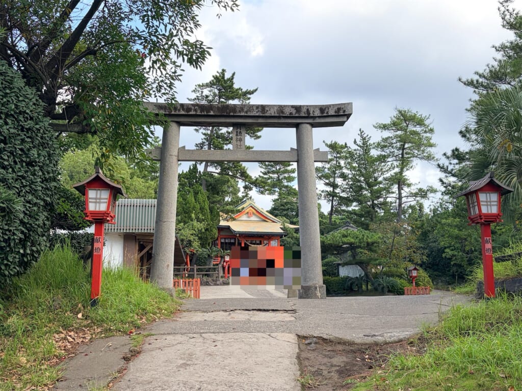 月讀神社の石の鳥居と、赤い灯籠が並ぶ参道